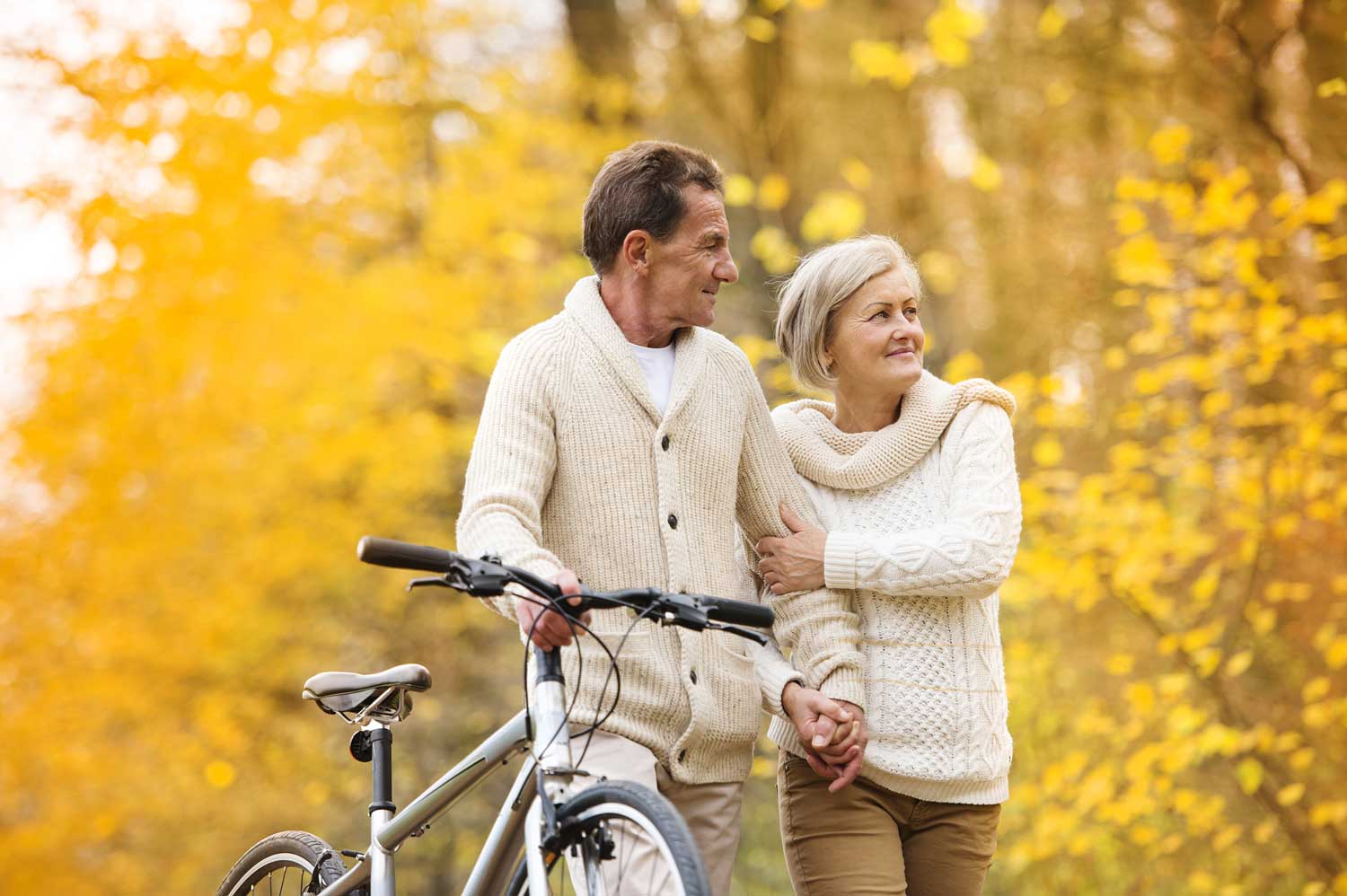 retired couple biking on a path